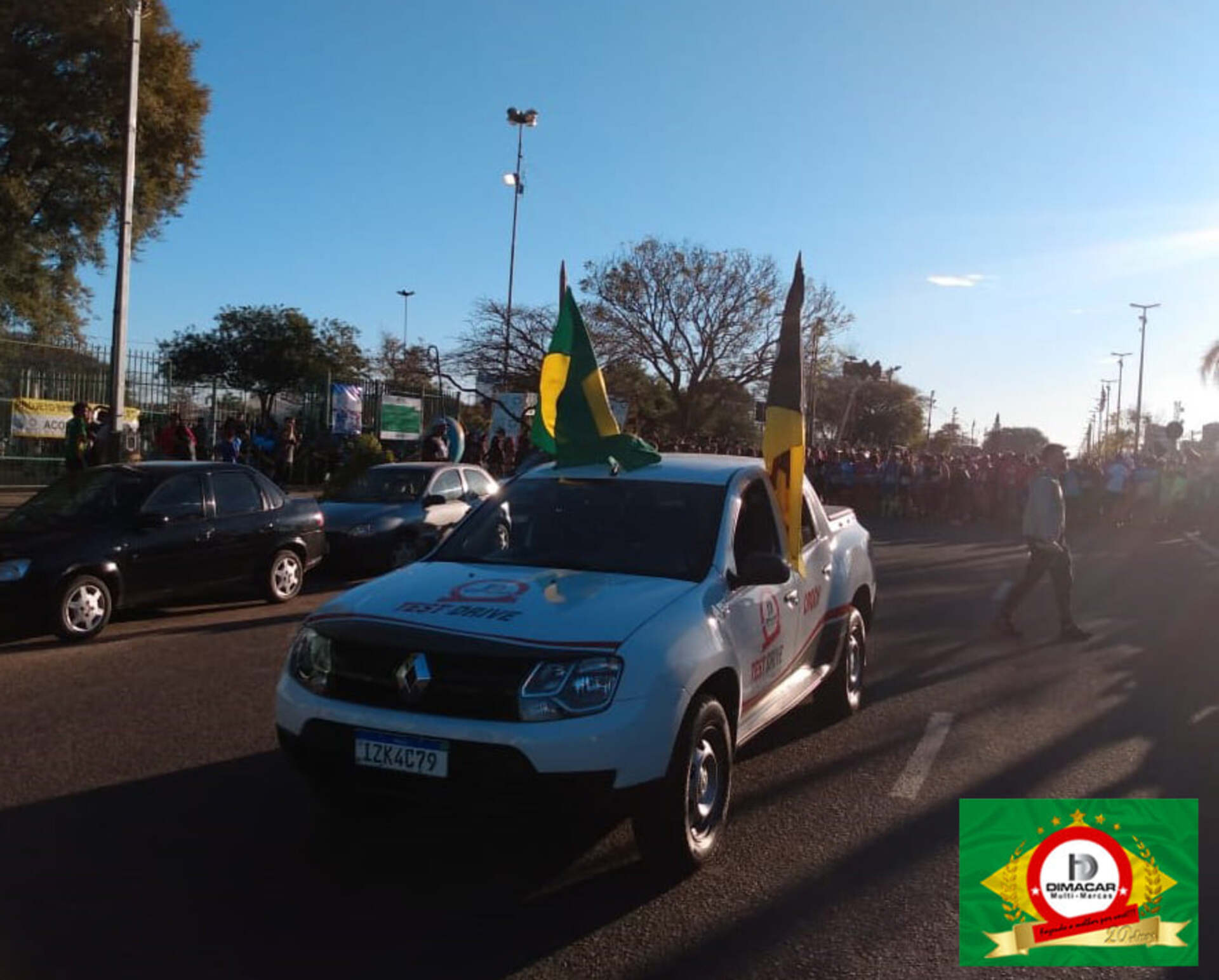 Carro-madrinha com bandeiras do Brasil e da Acoru e atletas prontos para a largada
